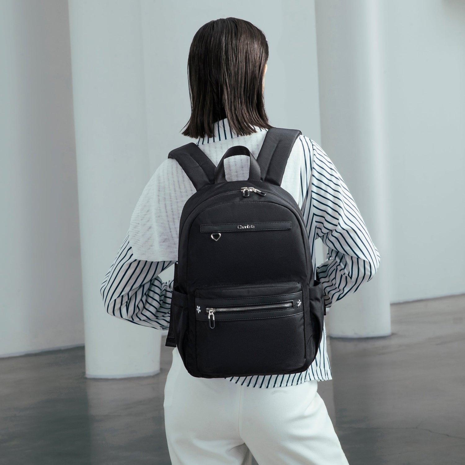 Frau trägt ein Minimalistischer Rucksack im Schwarz in Alltäglicher Outfit