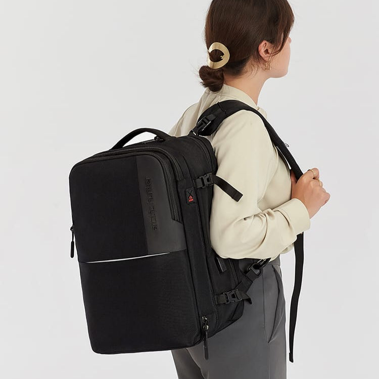 Dame mit schwarzem 35-Liter-Rucksack in seitlicher Ansicht, der das Volumen und Design des Rucksacks zeigt.