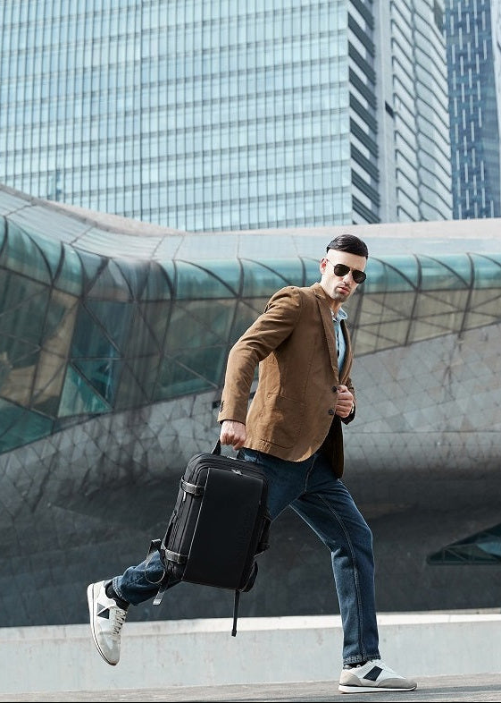 Mann trägt hochwertigen, erweiterten schwarzen Business Rucksack in Bewegung – dynamisch unterwegs für Arbeit, Stadt oder Reisen