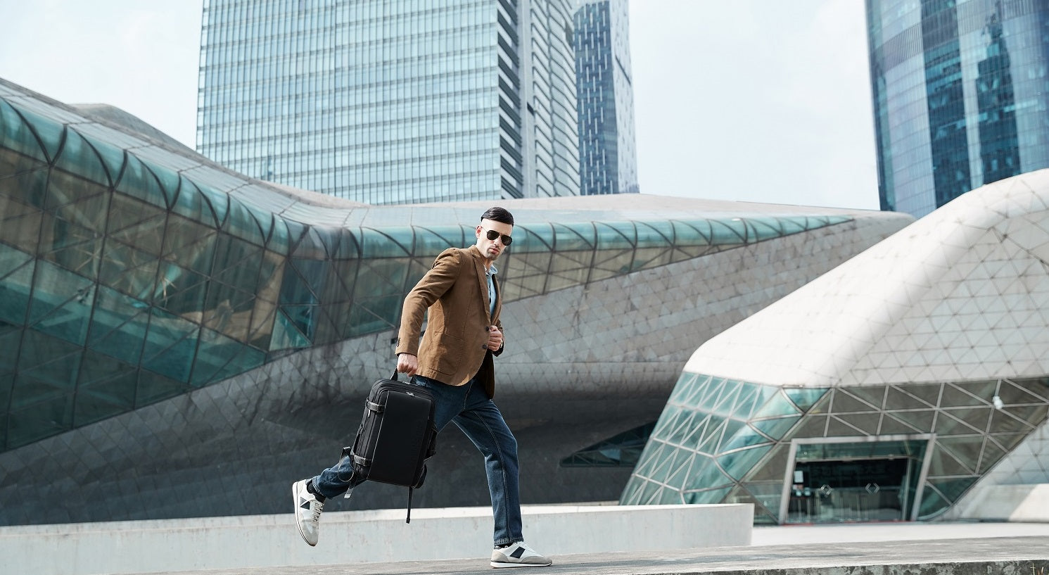 Herren Model trägt den Expandable Explorer Rucksack – stilvoller und erweiterbarer Begleiter für Alltag und Reisen