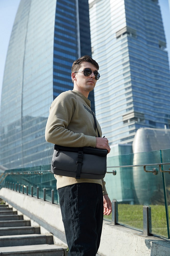 Mann trägt Arctic Hunter Crossbody Charm Tasche über der Schulter beim Reisen