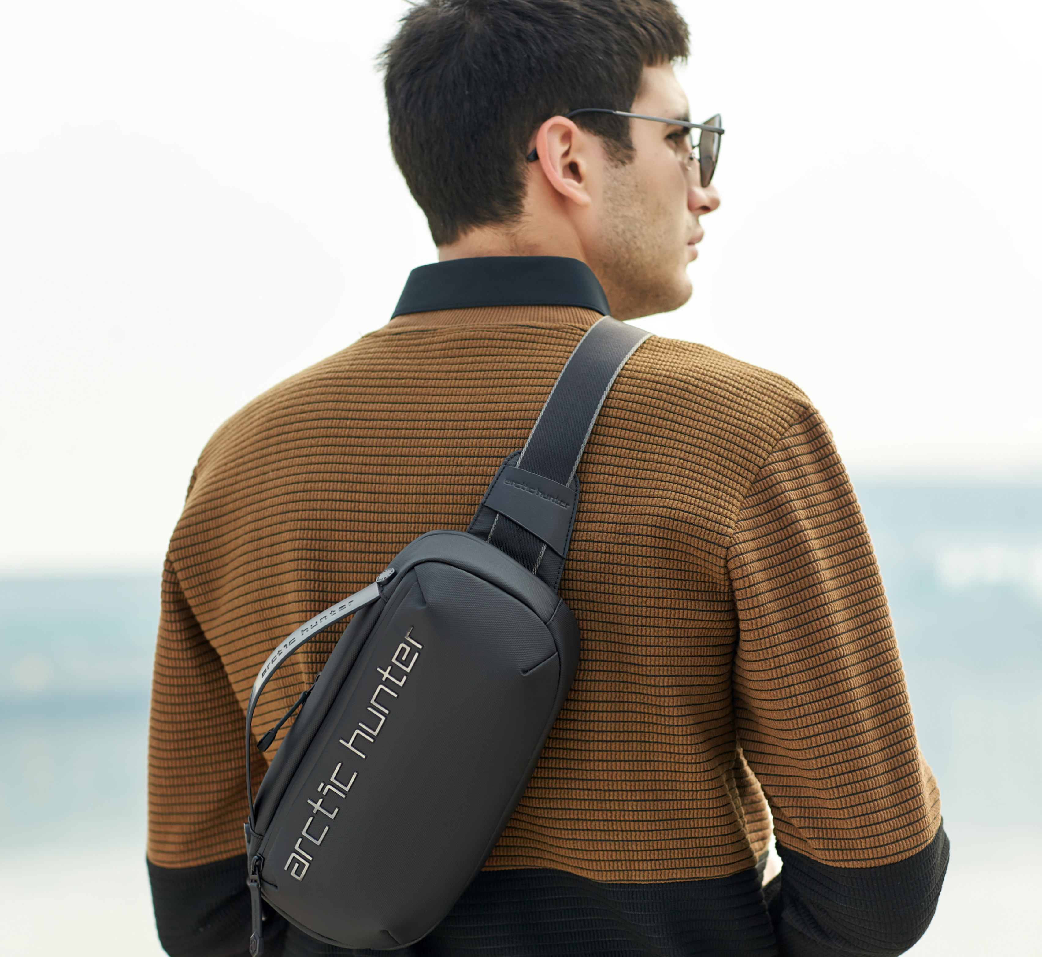 Mann trägt die Freeway Sling Crossbody Bag im urbanen Alltag