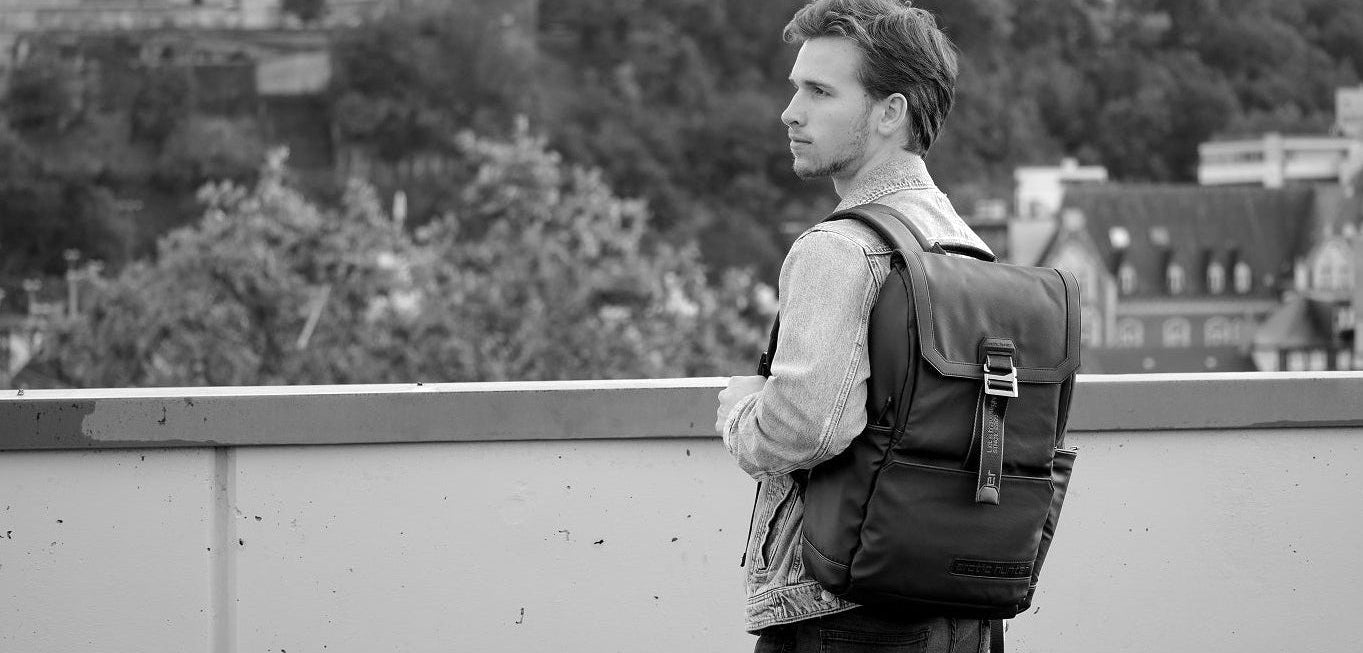Mann trägt urbanen Herren-Rucksack in der Stadt, moderner urbane Hintergrund, Alltag und Arbeit