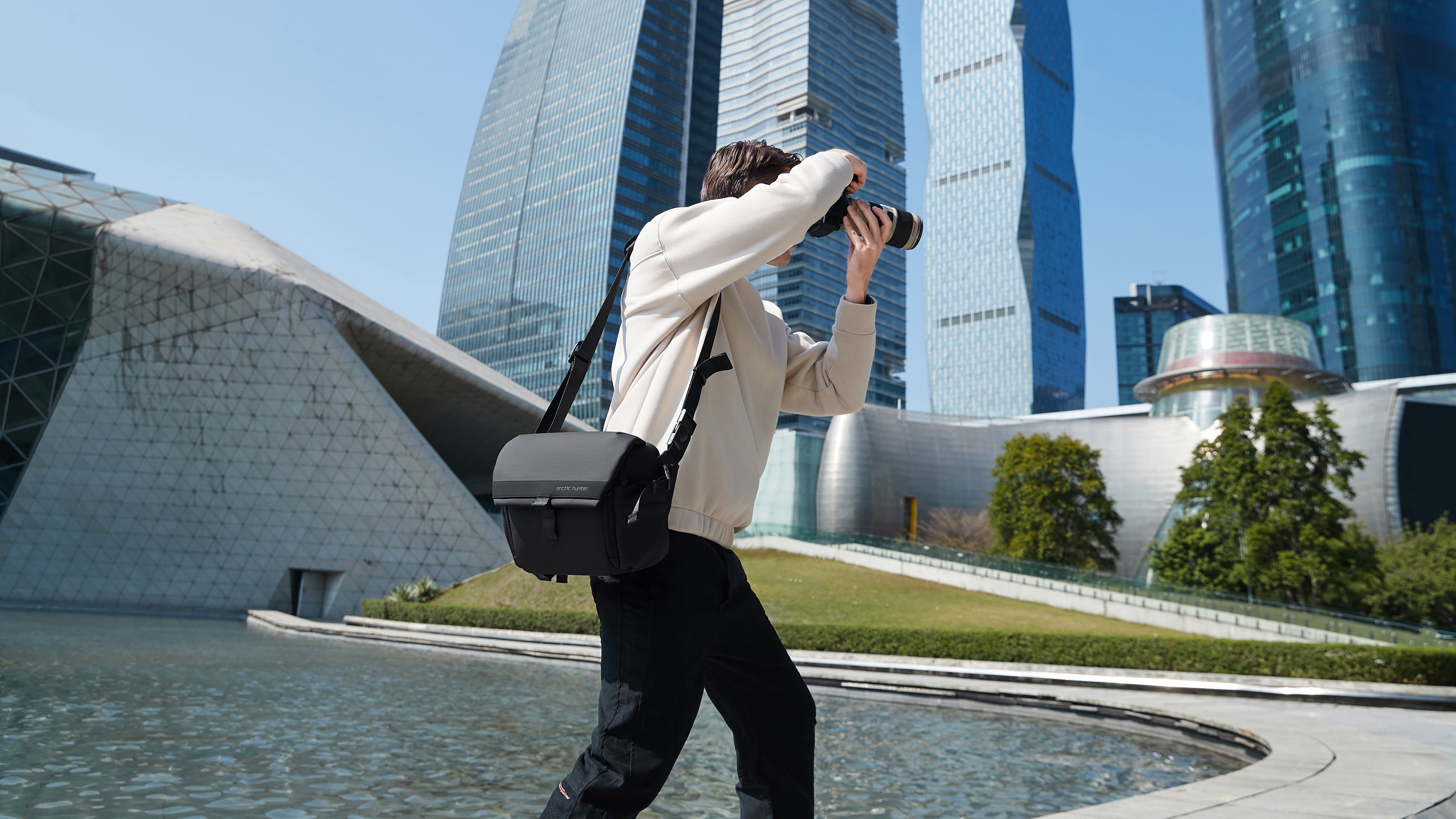 Fotograf mit ArcticFlex Pro Kameratasche fotografiert in moderner Stadtkulisse – zeigt hochwertige Verarbeitung und langlebige Qualität