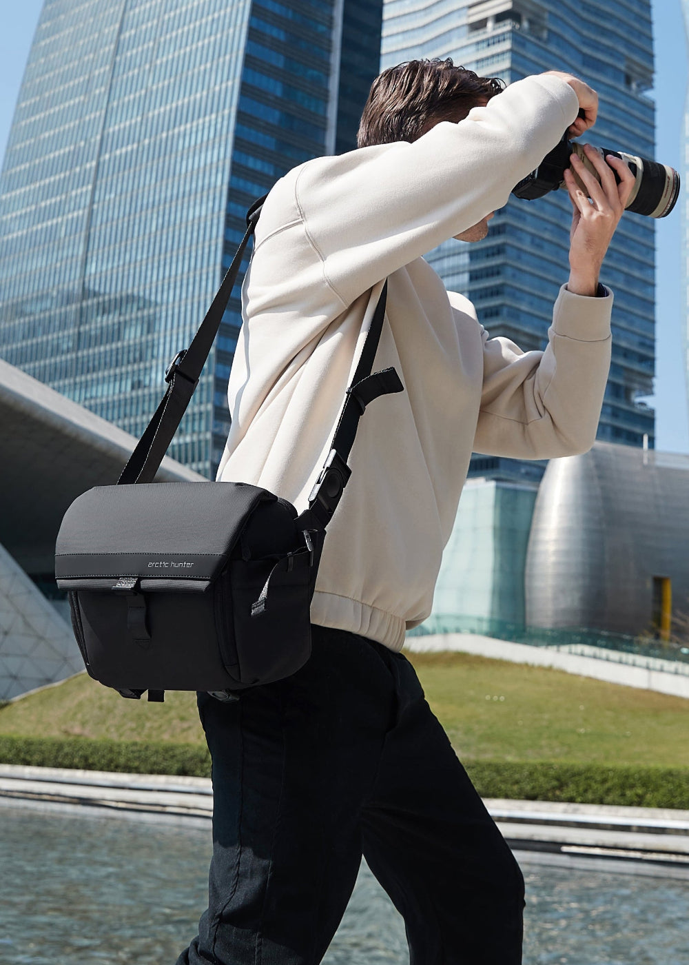 Fotograf mit Premium Kameratasche - ArcticFlex Pro fotografiert in moderner Stadtkulisse – zeigt hochwertige Verarbeitung und langlebige Qualität.
