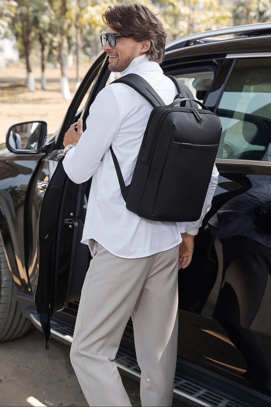 Man trägt einen Moderner Business Rucksack schwarz mit Laptopfach für Arbeit und Reisen
