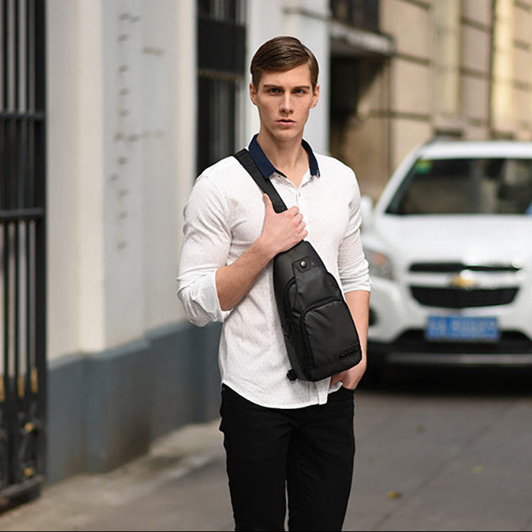 Ein Mann trägt die Solid Pro Umhängetasche von Arctic Hunter im urbanen Stadtalltag – modernes, minimalistisches Design trifft auf Funktionalität für unterwegs in der Stadt.
