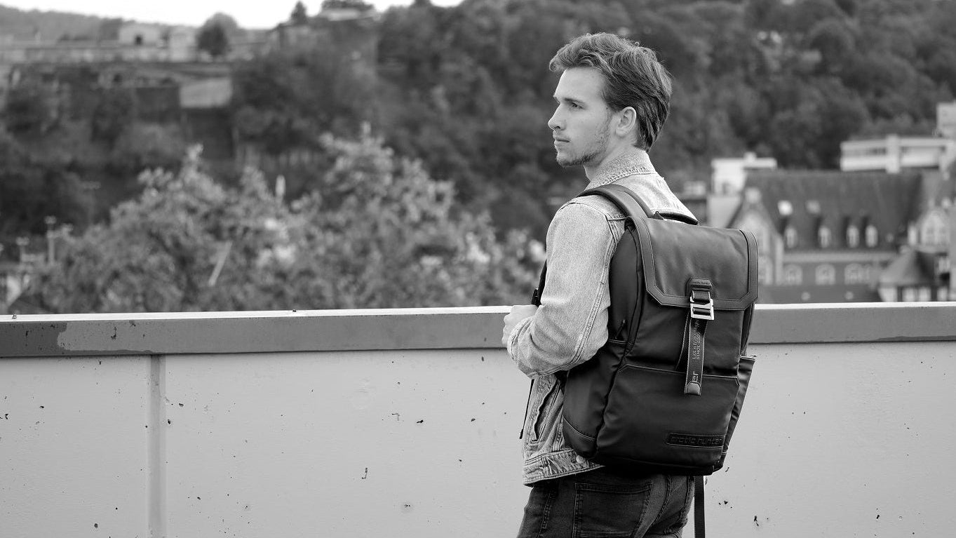 Mann trägt urbanen Herren-Rucksack in der Stadt, moderner urbane Hintergrund, Alltag und Arbeit