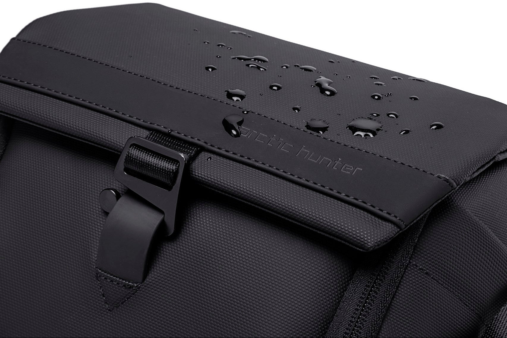 Nahaufnahme der wasserabweisenden Oberfläche der ArcticFlex Pro Kameratasche mit Wassertropfen auf dem Deckel – zeigt robustes, wetterfestes Material.