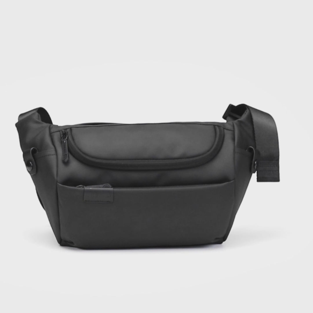 Video zeigt, wie Smartphone, Schlüssel, Geldbörse und weitere Essentials in der Whizy Crossbody Tasche verstaut werden. Anschließend wird die Tasche von einem Mann und einer Frau im Alltag getragen.