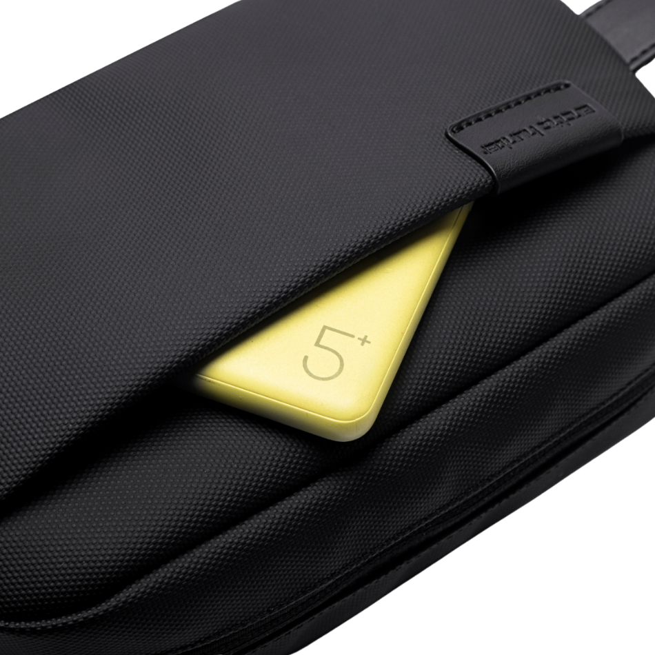 Detailansicht des Frontfachs der Pouch Bag Travel Lite mit einer gelben Powerbank – zeigt das wasserabweisende Material und den schnellen Zugriff auf Technik-Zubehör.