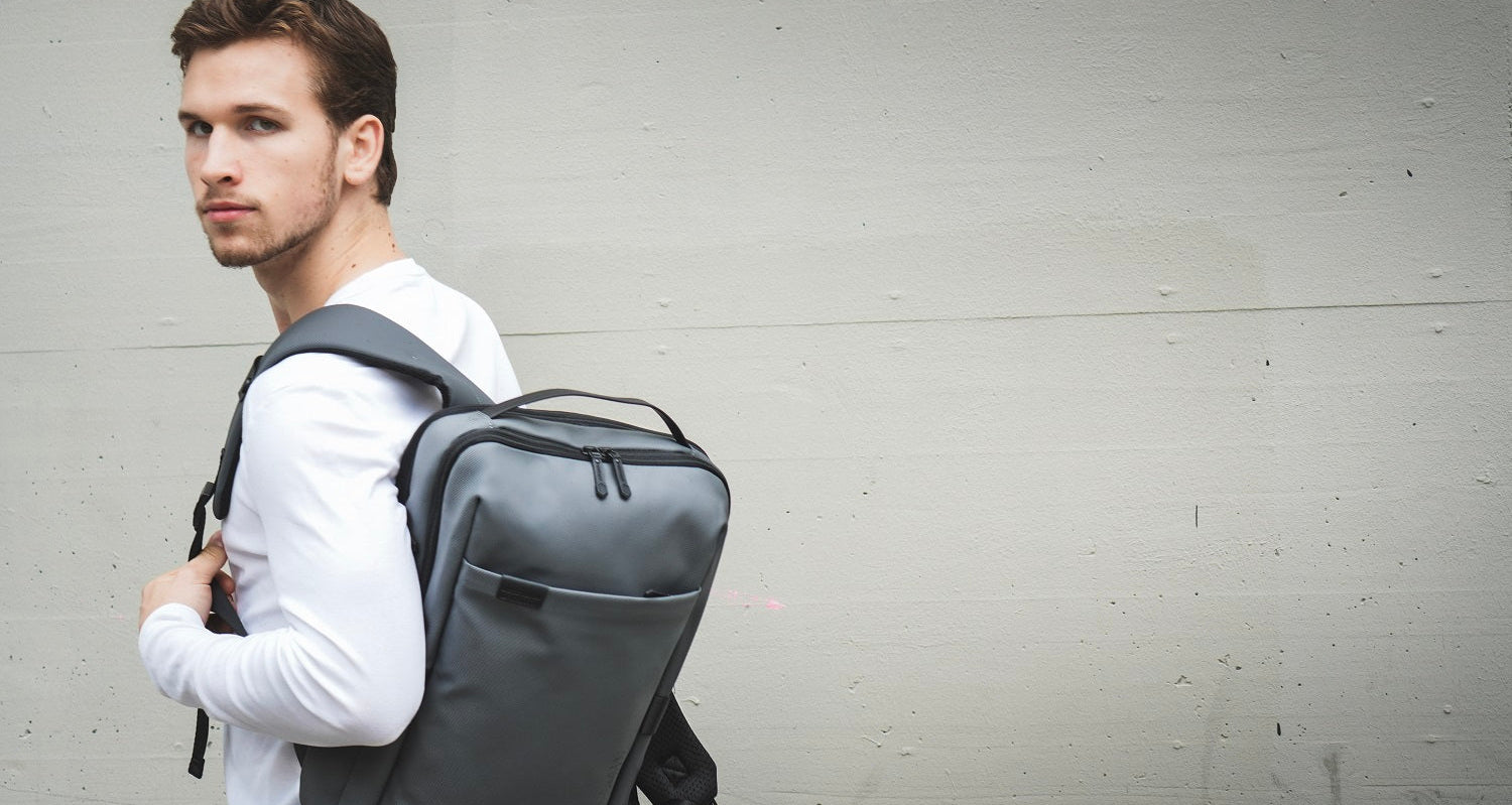 Unisex EasyCary Rucksack in Grau, getragen von einem Mann – moderner, wasserabweisender Backpack für Alltag, Arbeit und Reisen